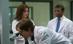 Peter Jahrling (Topher Grace), un virologiste civil, regarde à travers l'oculaire du microscope avec le Dr Nancy Jaax (Julianna Margulies) et Ben Gellis (Paul James) dans «The Hot Zone».