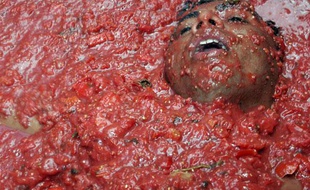 Un homme prend un bain de tomates lors du festival «Tomatina» à Bunol, Espagne, le 26 août 2009.