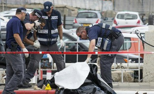 Les forces de sécurité israéliennes inspectent le corps d'un Palestinien abattu après avoir agressé au couteau une soldate israélienne et trois passants dans la ville côtière de Tel Aviv, en Israël, le 8 octobre 2015