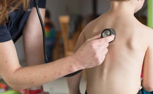 Un médecin ausculte un petit garçon
