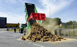 Un tracteur déverse des déchets pour bloquer l'entrée du site.