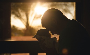 Illustration d'un père prenant dans ses bras un nourrisson. Les hommes aussi peuvent être touchés par la dépression post partum, un sujet longtemps tabou.