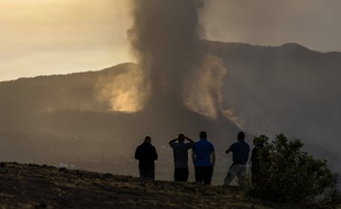 Des habitants regardent la fumée et la lave après l'éruption volcanique sur l'île de La Palma aux Canaries.