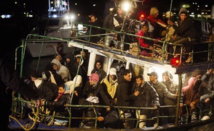 Un bateau rempli d'immigrants arrive dans le port de Lampedusa en Italie, le 21 février 2011.