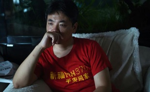 Jiang Hui, le fils d'une passagère du MH370, devant sa télévision le 30 juillet 2015 à Pékin