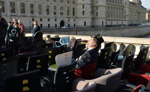 Un manifestant déguisé en banquier au milieu de chaises prises dans des banques, le 8 février 2016, près du palais de justice de Paris