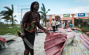 Une femme ramasse des débris métalliques suite au passage du cyclone Idai, à Beira, au Mozambique