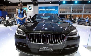 A model poses next to a BMW Active Hybrid 7L during a press preview for the 34th Bangkok International Motorshow on March 26, 2013. The 34th Bangkok International Motorshow will be held from March 27 to April 7. AFP PHOTO/PORNCHAI KITTIWONGSAKUL