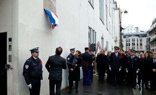 François Hollande et Anne Hidalgo dévoilent une plaque à la mémoire des victimes des attaques contre Charlie Hebdo le 5 janvier 2016 devant le siège de l'hebdomadaire satirique à Paris