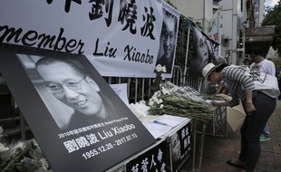 Hong-Kong, le 14 juillet 2017. Une femme rend hommage à Liu Xiaobo, prix Nobel de la paix en 2010, après sa mort.