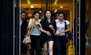 Une groupe de jeunes femmes sortent d'un centre commercial à Pékin, le 13 août 2014