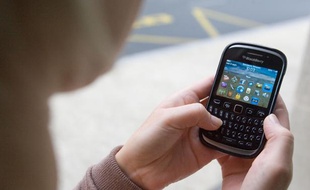 Illustration: Une jeune femme utilise un smartphone.