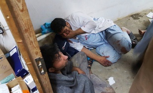 Des membres du personnel de l'hôpital MSF de Kundunz se retranchent dans une des pièces de l'établissement, après son bombardement, le 3 octobre 2015.