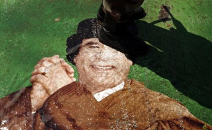 Un rebelle libyen marche sur un portrait de Mouammar Khadafi, le 22 juin 2011 à Benghazi.