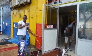Des hommes nettoient leurs bureaux à Monrovia contre l'épidémie d'Ebola le 1er août 2014