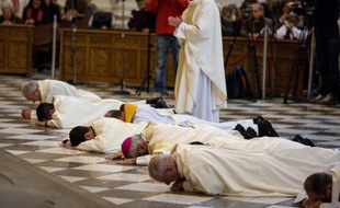 L'archevêque de Grenade, Mgr Francisco Javier Martinez (3e à d), se prosterne lors d'une messe avec d'autres religieux dans la cathédrale de la ville le 23 novembre 2014, en signe d'excuse envers les victimes d'abus sexuels de la part de prêtres