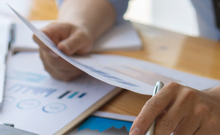 The young businessman uses a numerical calculator to calculate the numbers of the company's financial documents.He is analyzing the company's financial graphs.