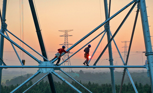 Des employés travaillant sur une tour de transmission haute tension à Yichun, dans la province centrale du Jiangxi en Chine, el 28 septembre 2021.