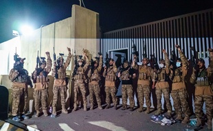A l'aéroport de Kaboul, des combattants talibans brandissent des armes, de l'équipement et des uniformes américains peu après le départ des Etats-Unis, le 31 août 2021.