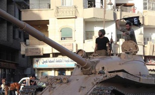 Image fournie par le média jihadiste Welayat Raqa, le 30 juin 2014, montrant des jihadistes de l'Etat islamique sur un char dans une rue de Raqa, en Syrie