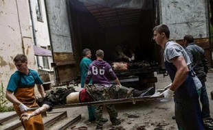 Des secours médicaux et des militants pro-Russes chargent des corps de combattants pro-Russes à Donetsk, le 27 mai 2014