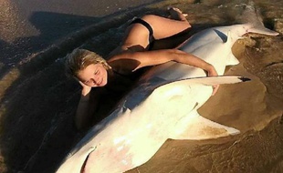 Elle prend la pose avec un requin mort