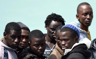 Des migrants secourus attendent avant de débarquer dans le port de Catane en Sicile le 24 avril 2015