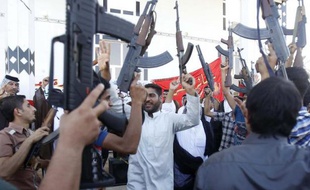 Des hommes appartenant à des tribus chiites brandissent des armes pour montrer leur détermination à rejoindre les forces de sécurité itakiennes pour lutter contre les jihadistes, à Karbala, le 17 juin 2014