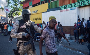 Intervention d'un policier lors d'une manifestation demandant le départ du président Jovenel Moïse, à Port-au-Prince le 7 février 2021.