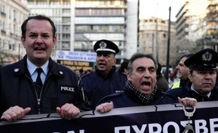 Des policiers en tenue ont bloqué jeudi l'entrée du bâtiment des forces anti-émeutes près du centre d'Athènes pour manifester contre de nouvelles coupes salariales envisagées par le gouvernement grec pour maintenir le pays dans la zone euro.