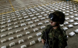 Un soldat colombien patrouille devant une importante saisie de cocaïne sur la base militaire de Bahia Solano, en Colombie, le 14 mars 2015