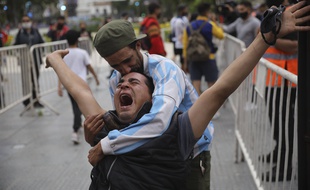 Des fans argentins en pleurs devant le Palais présidentiel argentin, où une veillée funèbre pour Diego Maradona doit durer toute la journée, le 26 novembre 2020.