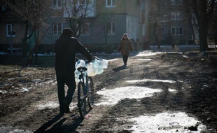 Un homme va chercher de l'eau avec son vélo le 17 février 2015 à Donetsk, dans l'est de l'Ukraine