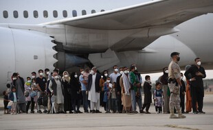 Des Afghans sur le tarmac de l'aéroport de Kaboul se préparent à évacuer vers l'Espagne, le 24 août 2021.
