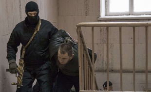 La police russe escorte l'un des cinq suspects dans le meurtre de Boris Nemtsov à Moscou.