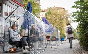 Les clients d'un café installés dans une serre pour se protéger du coronavirus, à Berlin, le 20 octobre 2020.