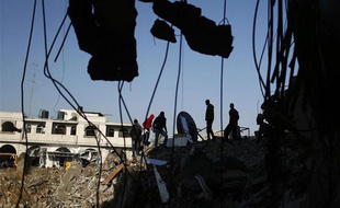 Des Palestiniens inspectent les décombres d'une maison à Gaza City le 20 novembre 2012.