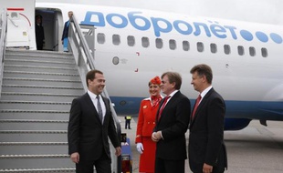 Le Premier ministre russe Dmitri Medvedev rencontre le patron d'Aeroflot et le ministre des transports Vitali Saveliev Maxim Sokolov devant un avion de la compagnie Dobroliot, filiale low-cost d'Aeroflot, à l'aéroport Cheremetievo de Moscou le 10 juin 2014