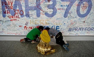 Des enfants écrivent des messages en hommage aux passagers disparus dans le vol MH370 de Malaysia Airlines, le 17 mars 2014