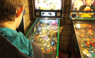 Un enfant joue sur l'un des flippers réparés par l'association.