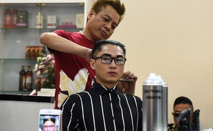 Un coiffeur vietnamien réalise la coiffure du leader nord-coréen, Kim Jong-un sur un client.