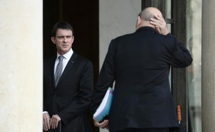 Le Premier ministre français Manuel Valls (g) discutent avec le ministre de la Défense Jean-Yves Le Drian au Palais de l'Elysée à Paris le 22 mars 2016
