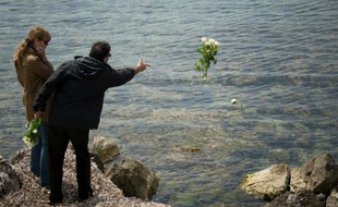 Un homme jette des fleurs à la mer lors d'un hommage pour Florence Arthaud, le 26 avril 2015 sur l'île Saint-Honorat