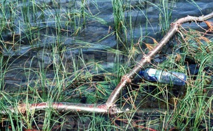 Une bouteille en plastique dans une rivière.