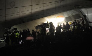 Les secours tentent de désincercérer les passagers toujours coincés dans le train accidenté, en Espagne, le 24 juillet 2013.