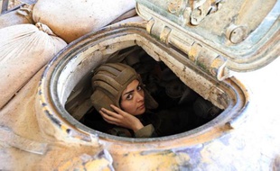 Une militaire syrienne conduit un char à Damas le 25 mars 2015