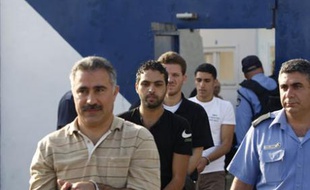 Palestinian prisoners walk with an Israeli prison guard (R) before their release from Ofer prison outside the West Bank city of Ramallah August 25, 2008. In what Israel has called a bid to bolster Palestinian President Mahmoud Abbas, who has been weakened by last year's takeover of the Gaza Strip by Hamas Islamists, Israeli authorities plan to release 199 Palestinian prisoners, many of them members of his Fatah faction, on Monday. REUTERS/Baz Ratner (WEST BANK)