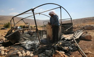 Un bédouin observe le 13 août 2015 à Ein Samiya, en Cisjordanie occupée, l'abri de stockage détruit par un incendie qui selon une ONG israélienne pourrait être un nouvel acte d'extrémistes juifs