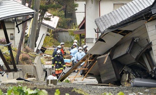 Des pompiers et des secouristes au milieu de maisons effondrées après le tremblement de terre à Hakuba, dans la préfecture de Nagano, Japon, le 23 novembre 2014.