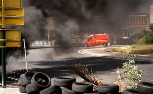 Un camion de pompiers arrive sur les lieux d'un barrage érigé par des militants de l'Union générale des travailleurs de Guadeloupe UGTG, au rond-point de Perrin dans la commune des Abymes, en Guadeloupe, le 17 novembre 2021.